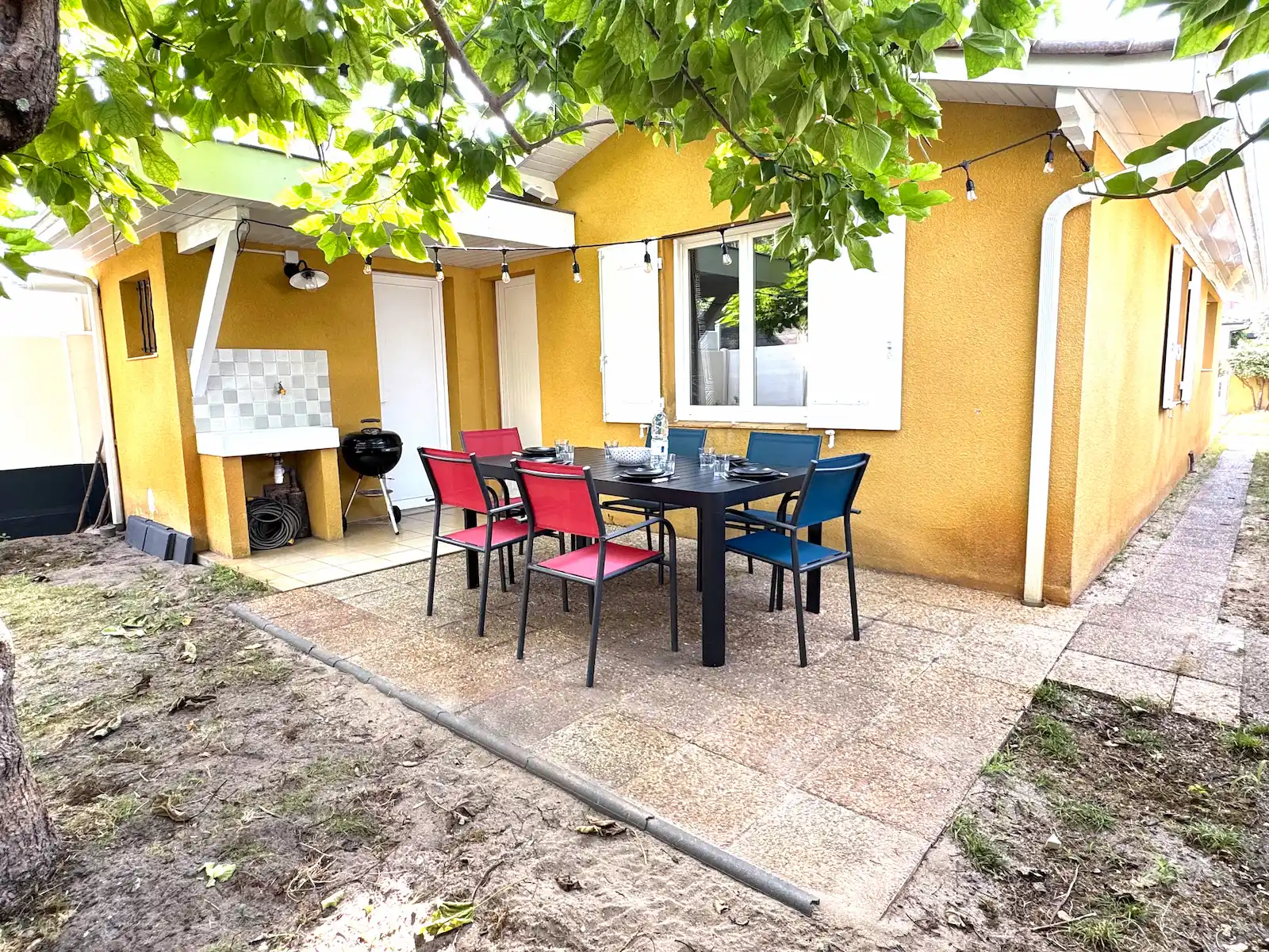 Terrasse ombragée avec table et chaises, coin repas extérieur – Andernos-les-Bains.