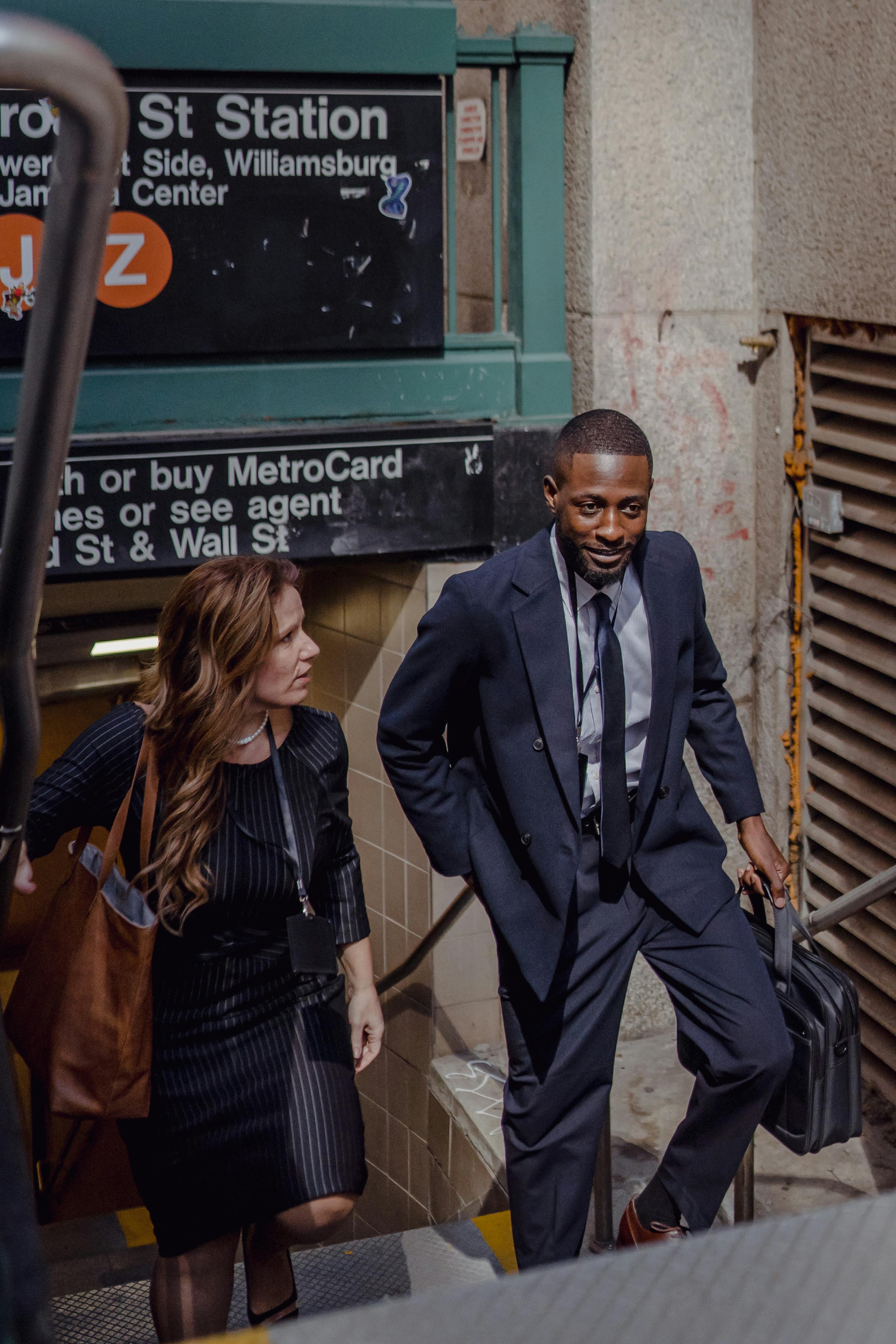 Two professionals walking up from a Lower Manhattan subway station near Wall Street