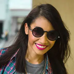 Fotografía de una mujer joven de piel morena y cabello largo negro, con expresión intelectual y entorno de estudio, representando el perfil de una estudiante de filosofía y letras.