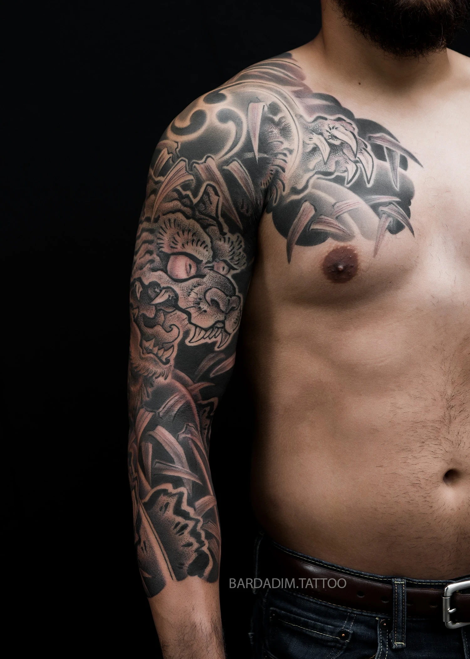 Front angle of the three quarter sleeve: the tiger's face with its pale eye on the upper arm, the clawed paw reaching onto the chest panel and bamboo below.