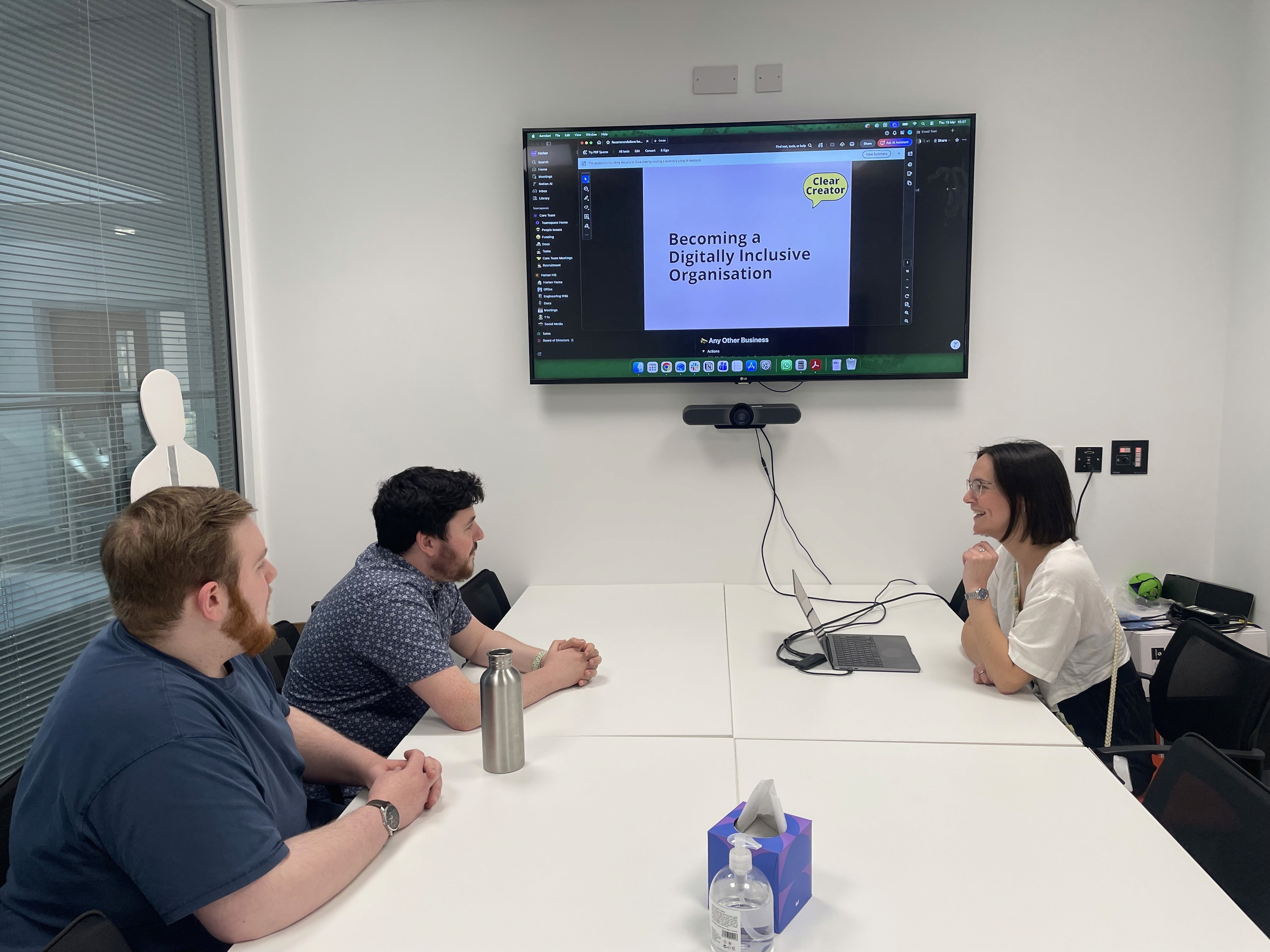 Zack, James, and Hannah sat at a meeting room table having a discussion.