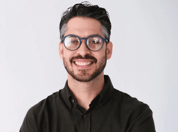 Young man in gray linen blazer over white henley shirt