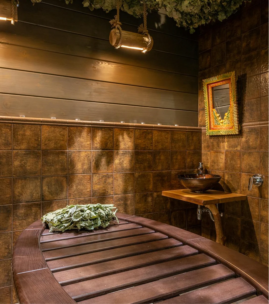 Warm spa treatment room with a massage bed, soft lighting, and natural decor.