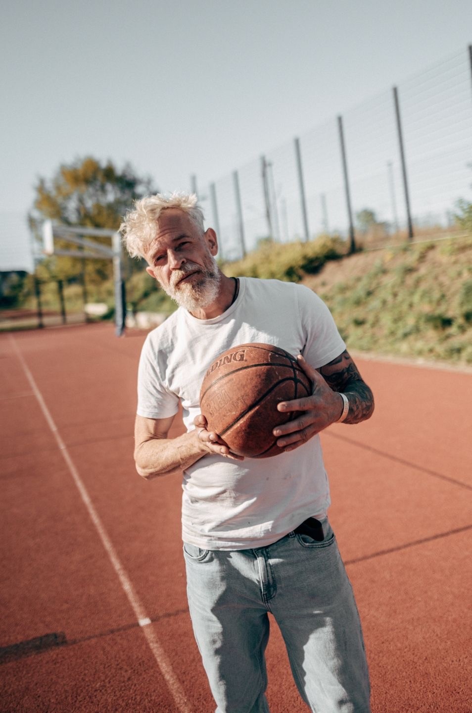locker stehende Pose Mann hält Basketball iund schaut entspannt 