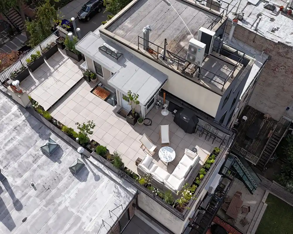 Custom TileTech Cenere-Cement pavers rooftop deck on Hybrid Pedestal base with planters, seating lounge, and grill in Park Slope, Brooklyn, NYC