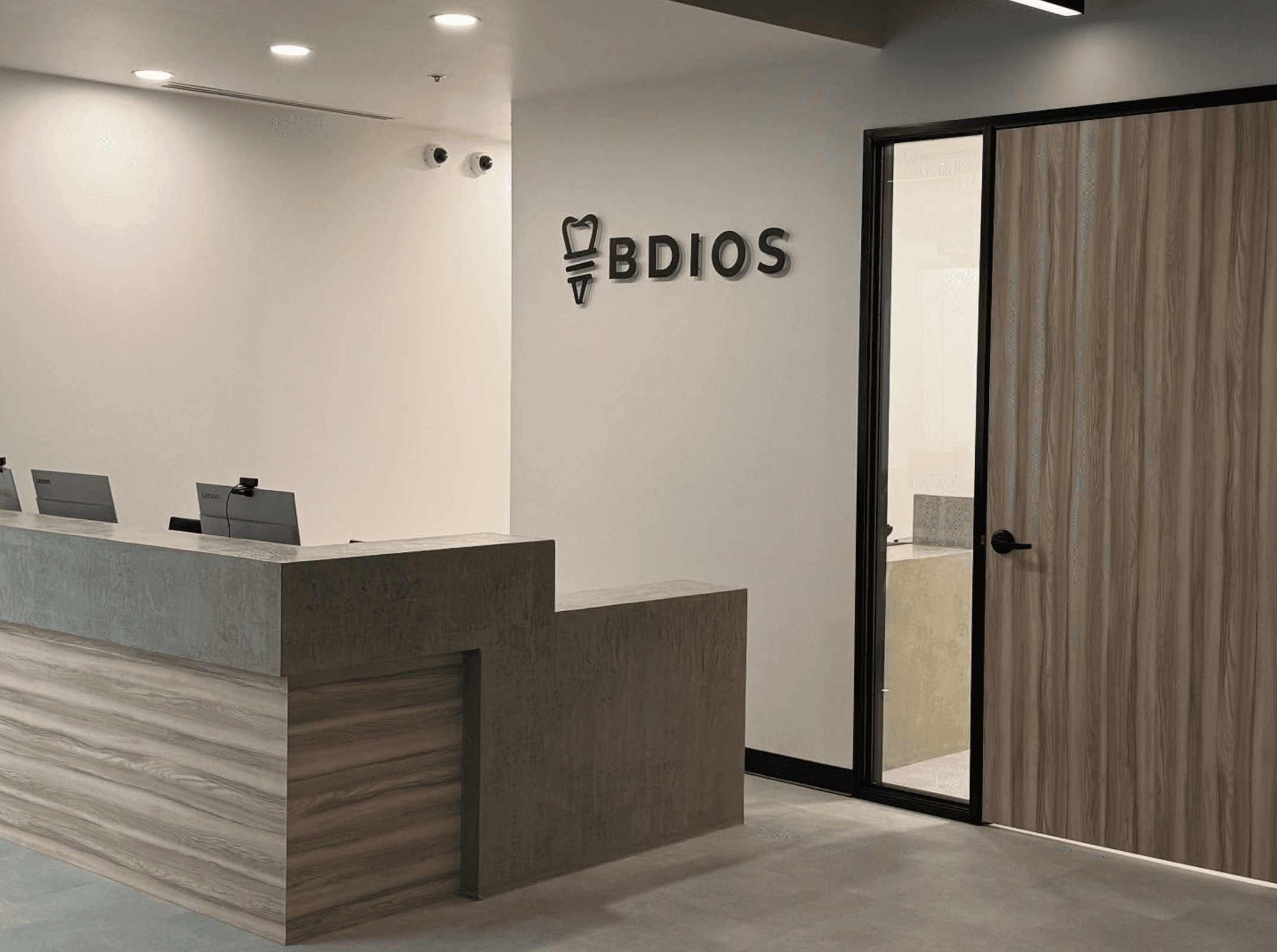 Modern clinic vanity with green tile wall, marble counter, and gold fixtures at Alinea Orthodontics.