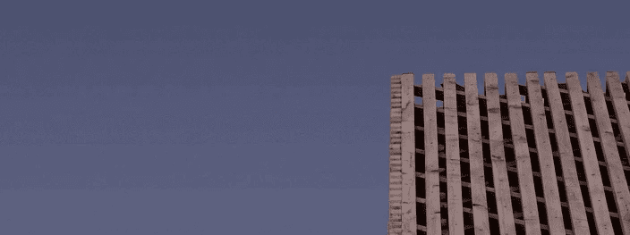 Dachkante aus Holzlatten steigt schräg in den violetten Abendhimmel