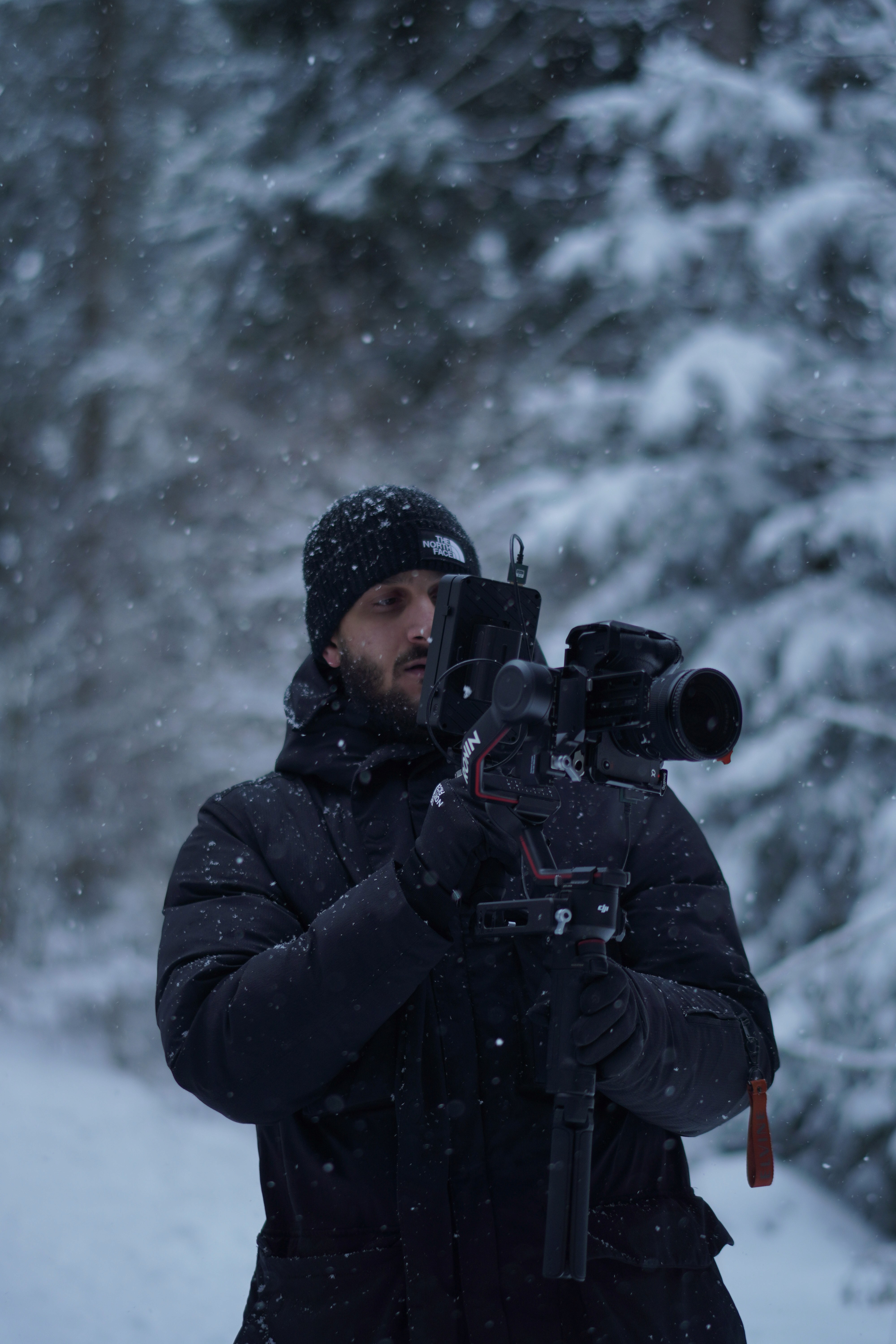Videograf mit Kamera beim Dreh im Schnee