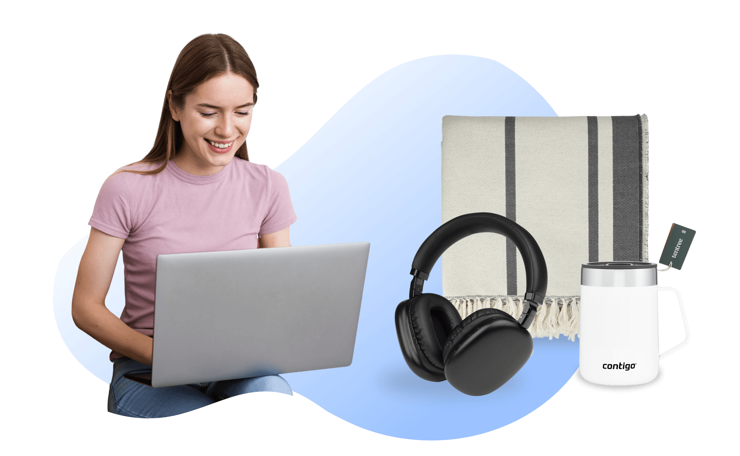 A woman on a laptop with a headphones, blanket, and tumbler on her side.