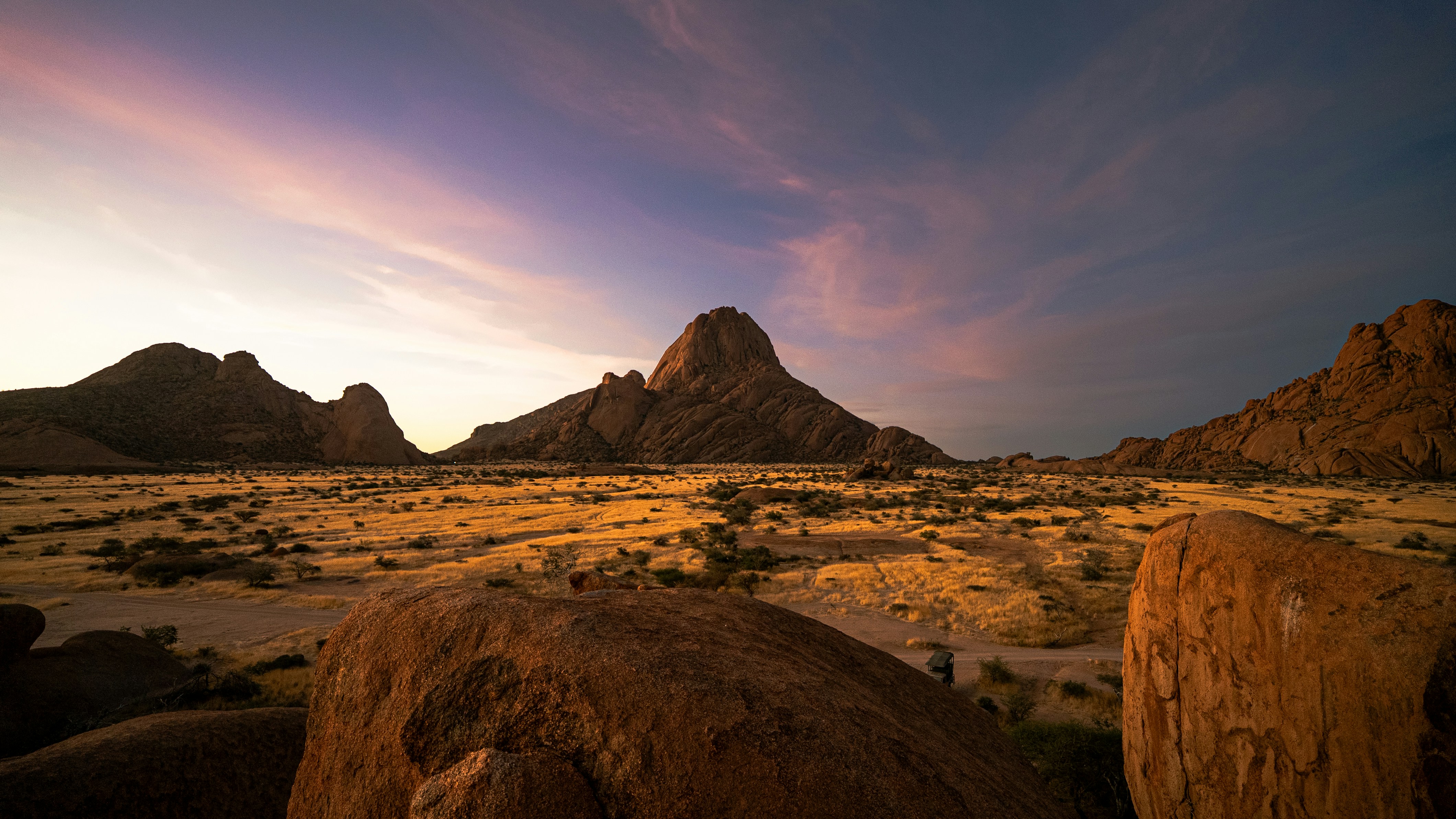 Rocky desert landscape at sunset with colorful sky