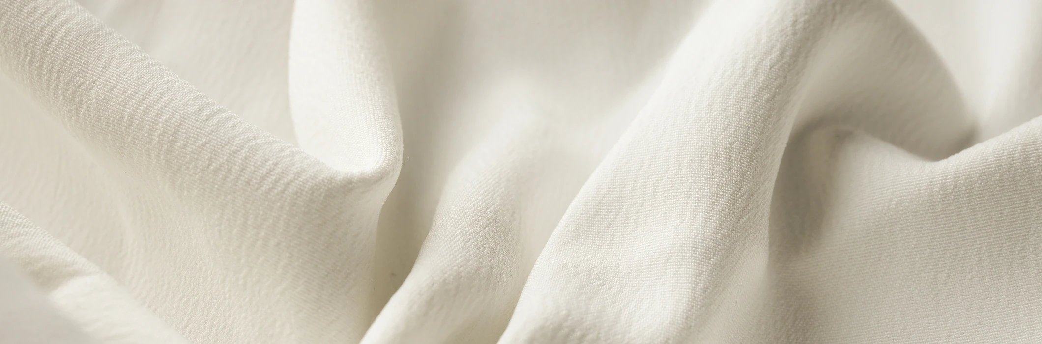 Текстура белой ткани с мягкими складками и освещением