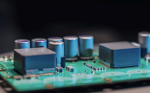 A close-up of a green circuit board populated with many electronic components.