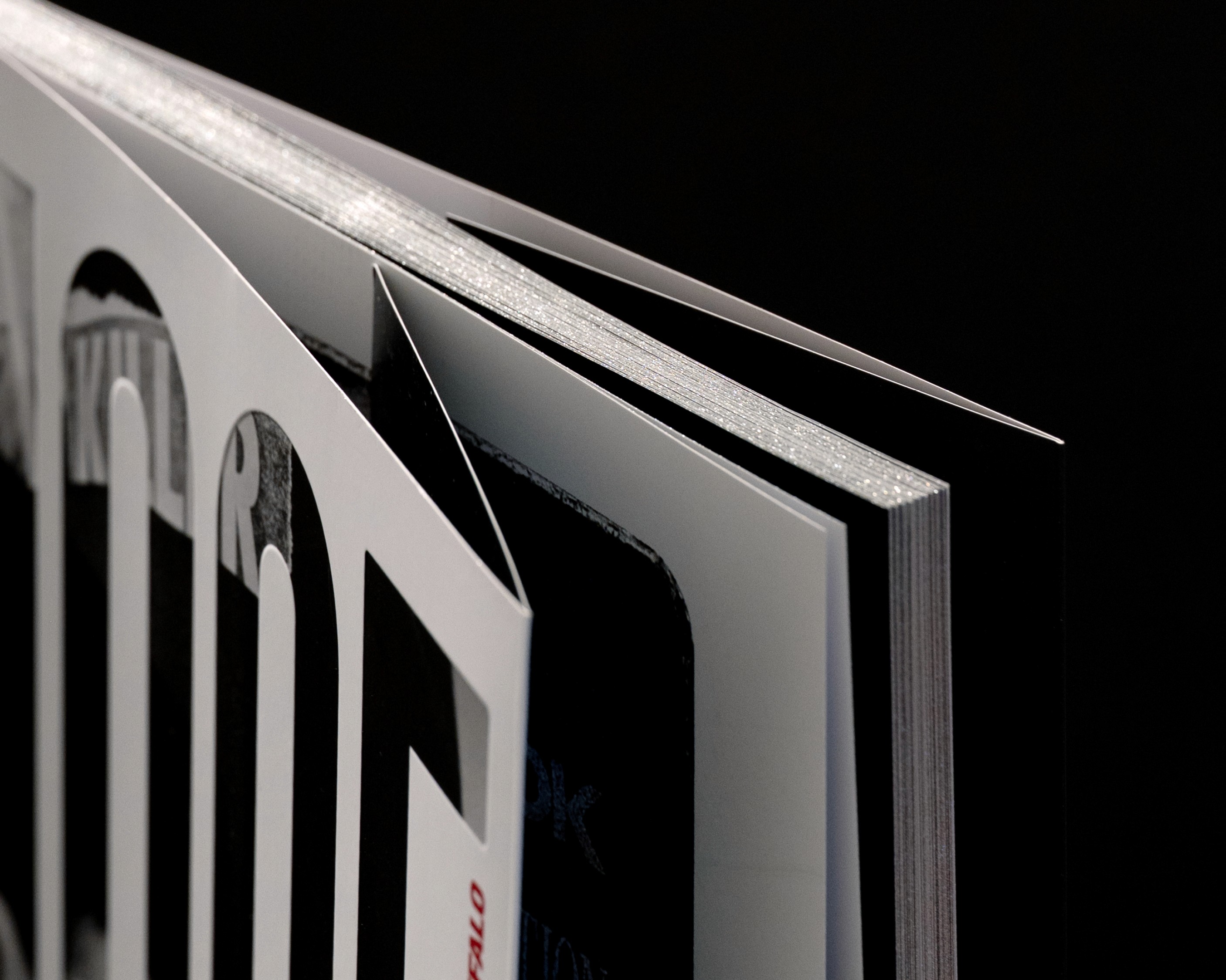A close-up of an open book with sleek pages set against a dark background.