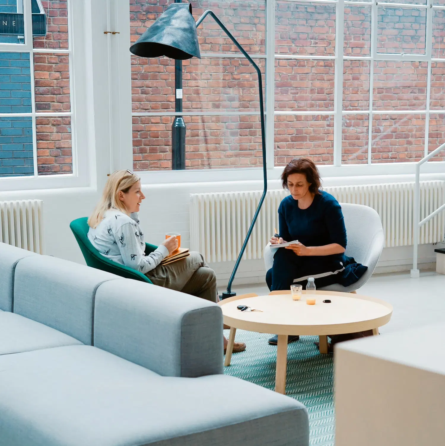 Two women in conversation during an in-person therapy session in Los Angeles, discussing mental health and personal growth in a supportive environment.