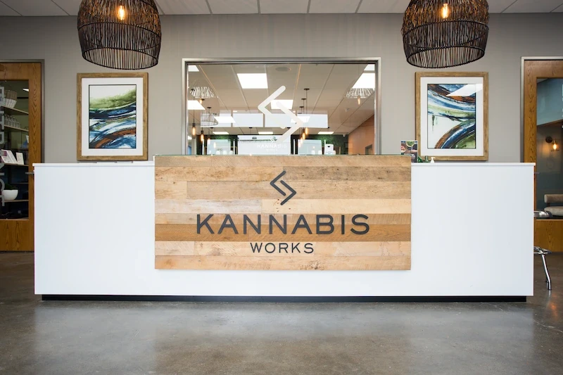 Close-up of Kannabis Works reception area with wooden signage and modern industrial decor.