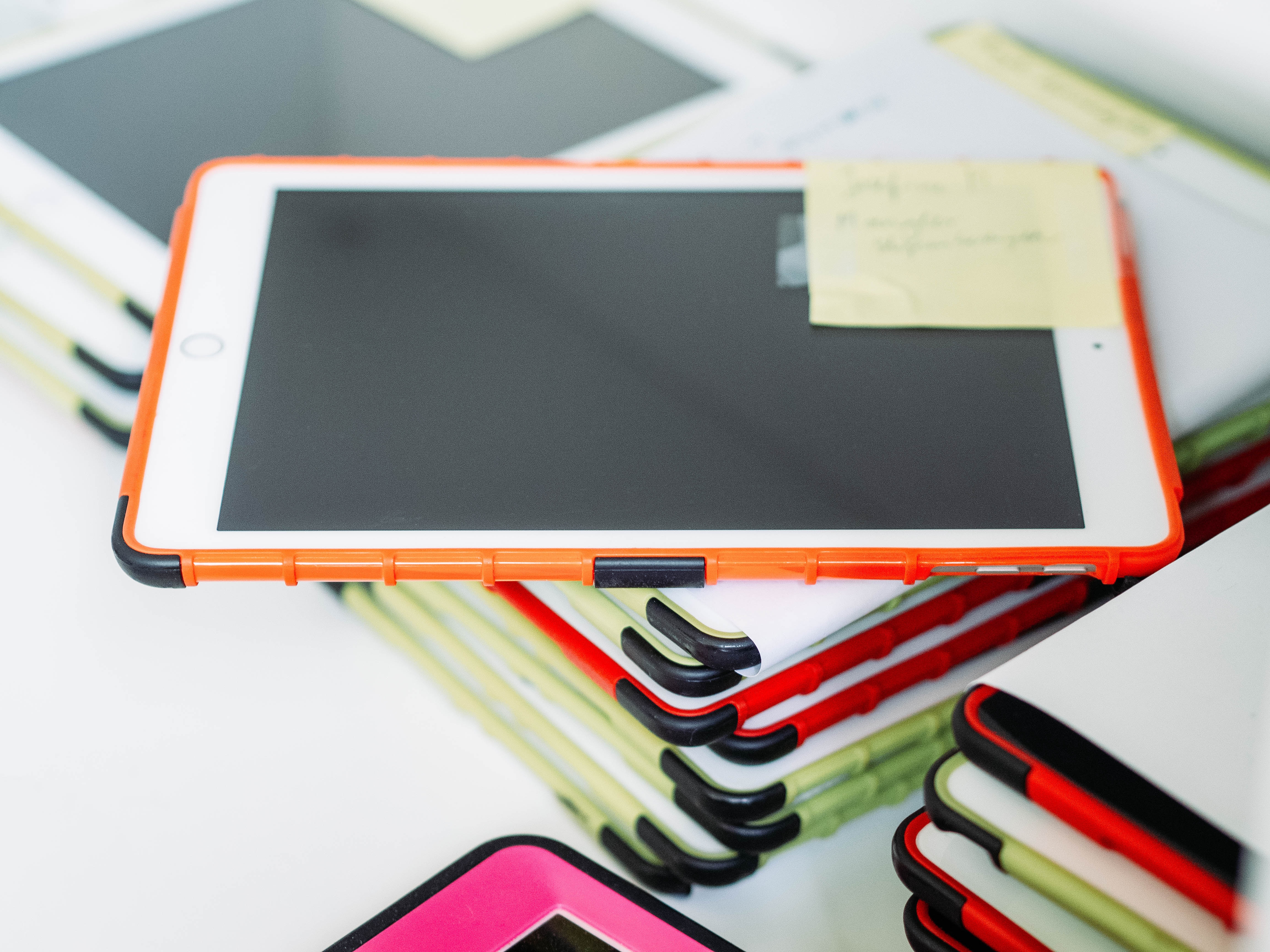 An ipad with a post it note on top of the screen