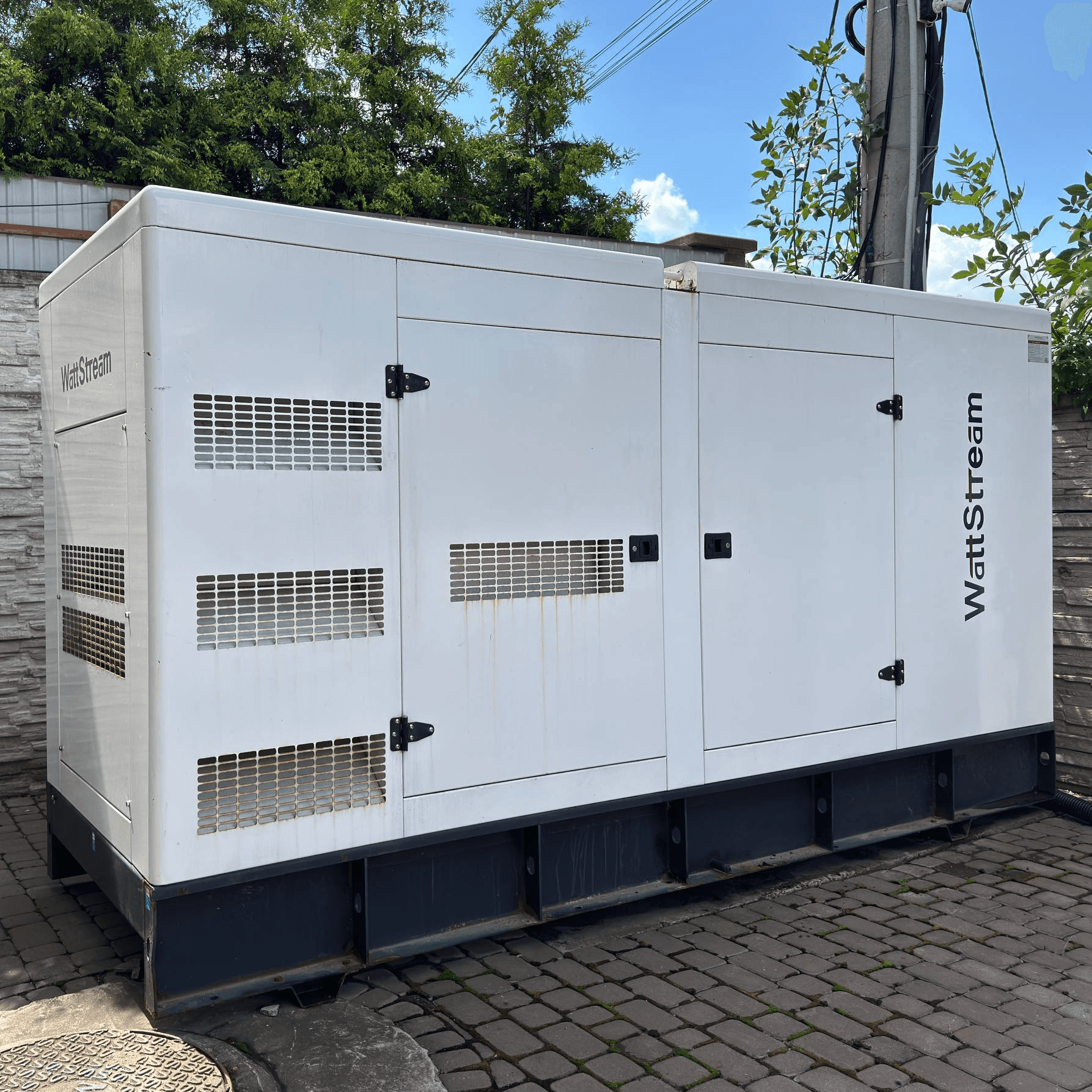 Потужний дизельний генератор WattStream, встановлений на подвір’ї.