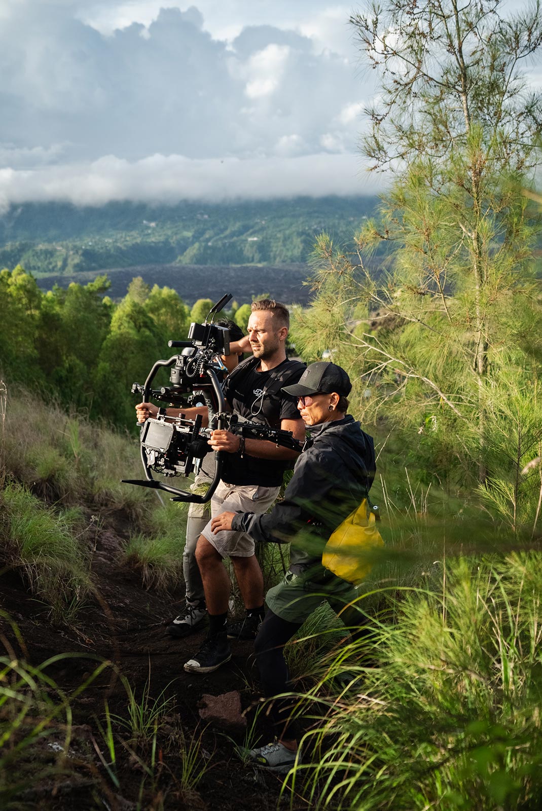 We Do Creative film crew on location during a commercial production shoot in Bali, filming in an open field with the island's tropical hills in the background