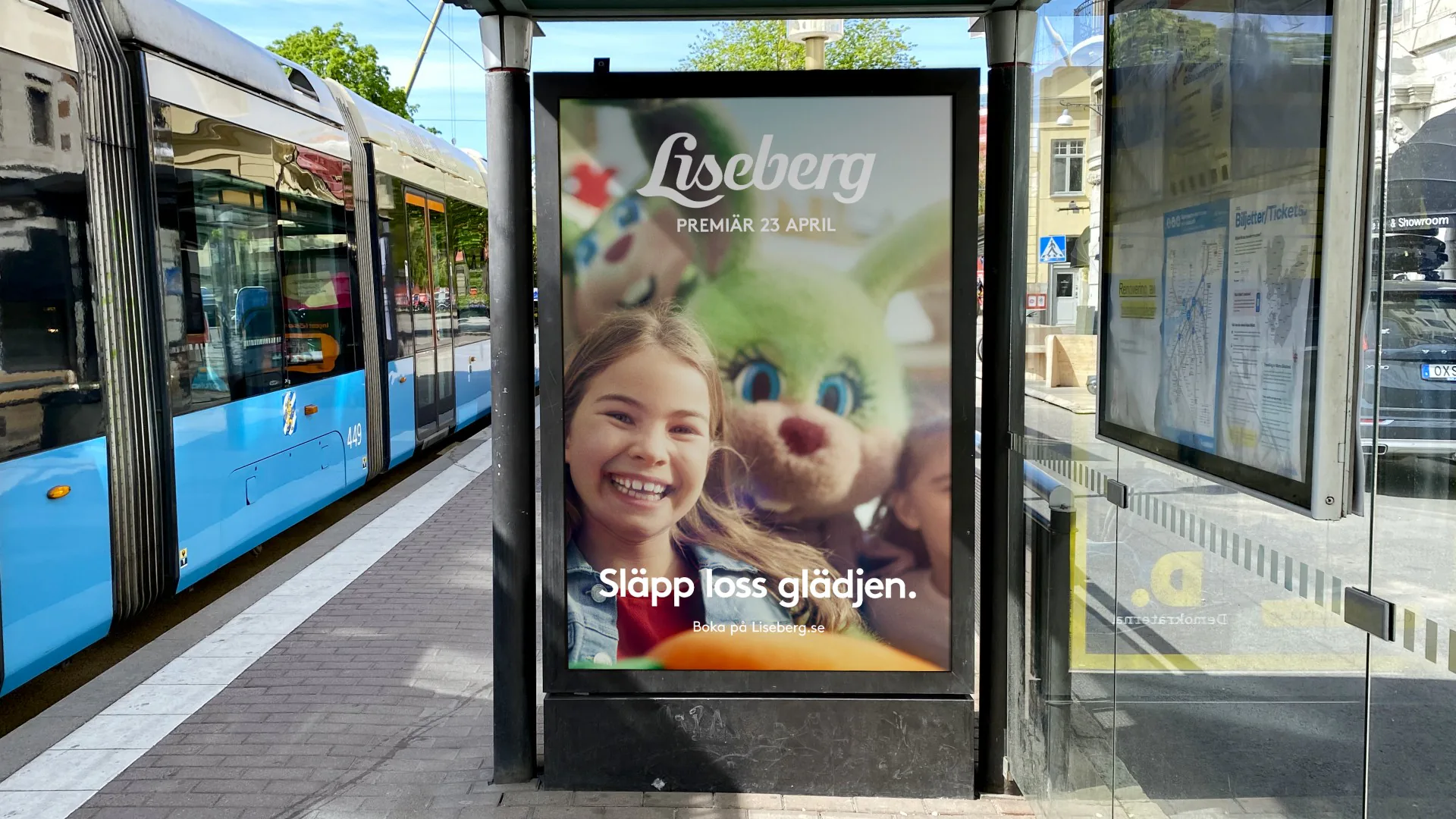 Liseberg-affisch med en flicka och en maskot i en hållplats, texten Släpp loss glädjen