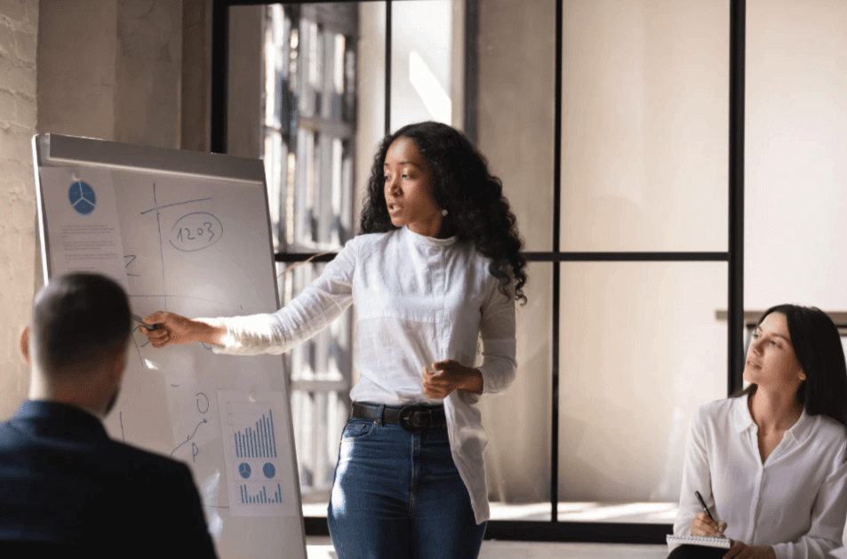 A luxurious bathtub filled with water and floating rose petals, surrounded by candles and greenery. The soft lighting creates a tranquil and romantic spa-like atmosphere.