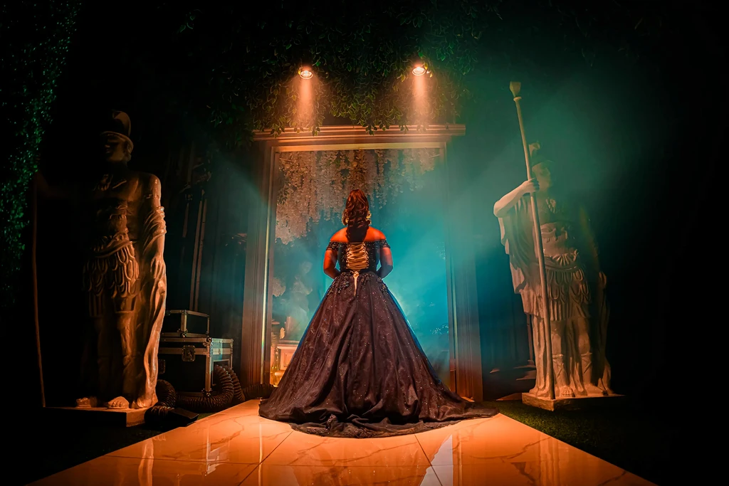Debutante in a midnight-blue ballgown between guardian statues at Pandora Hall, Stalla Suites Events Place Quezon City