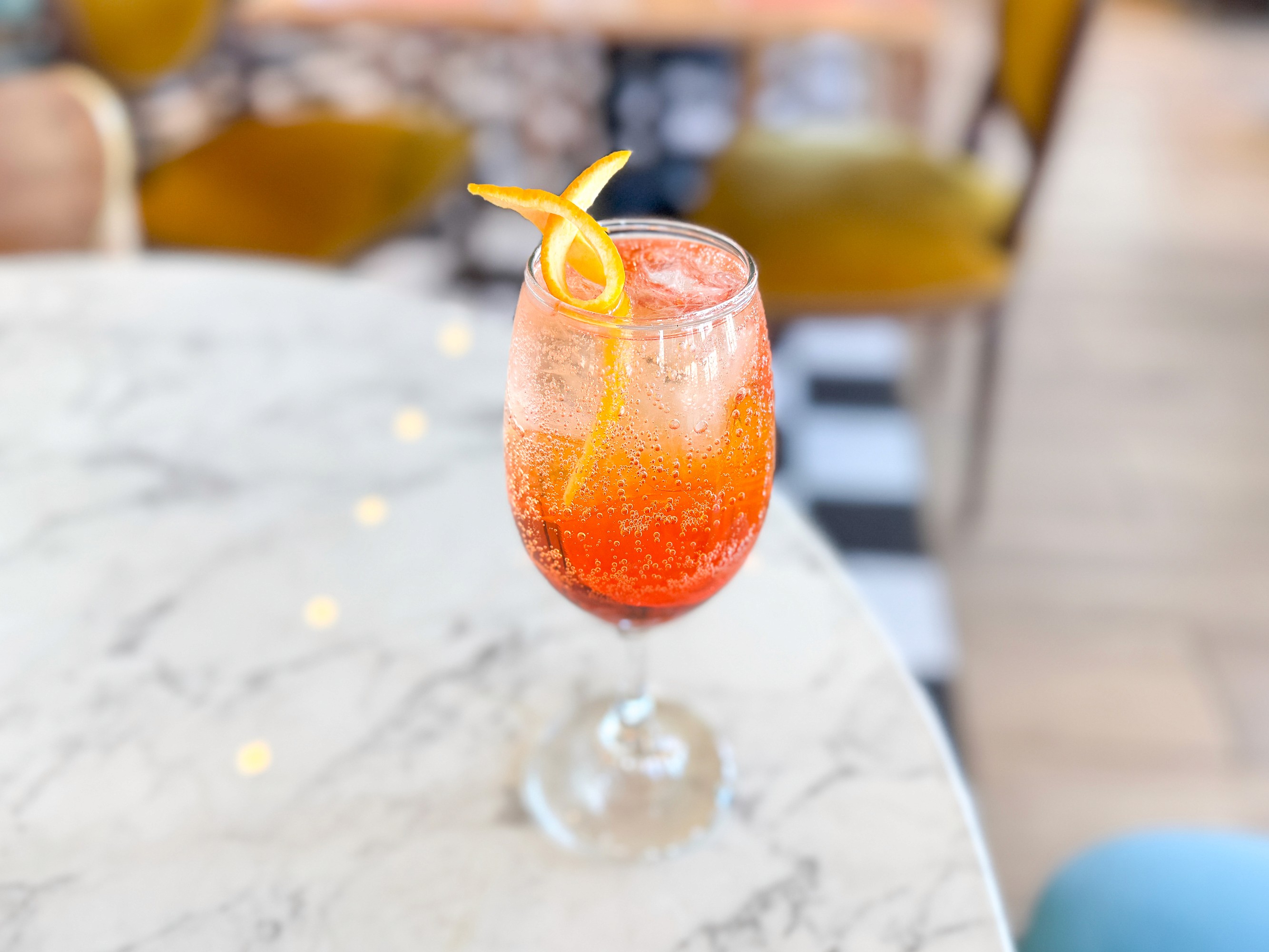 bebida fría en copa con tira de cítrico