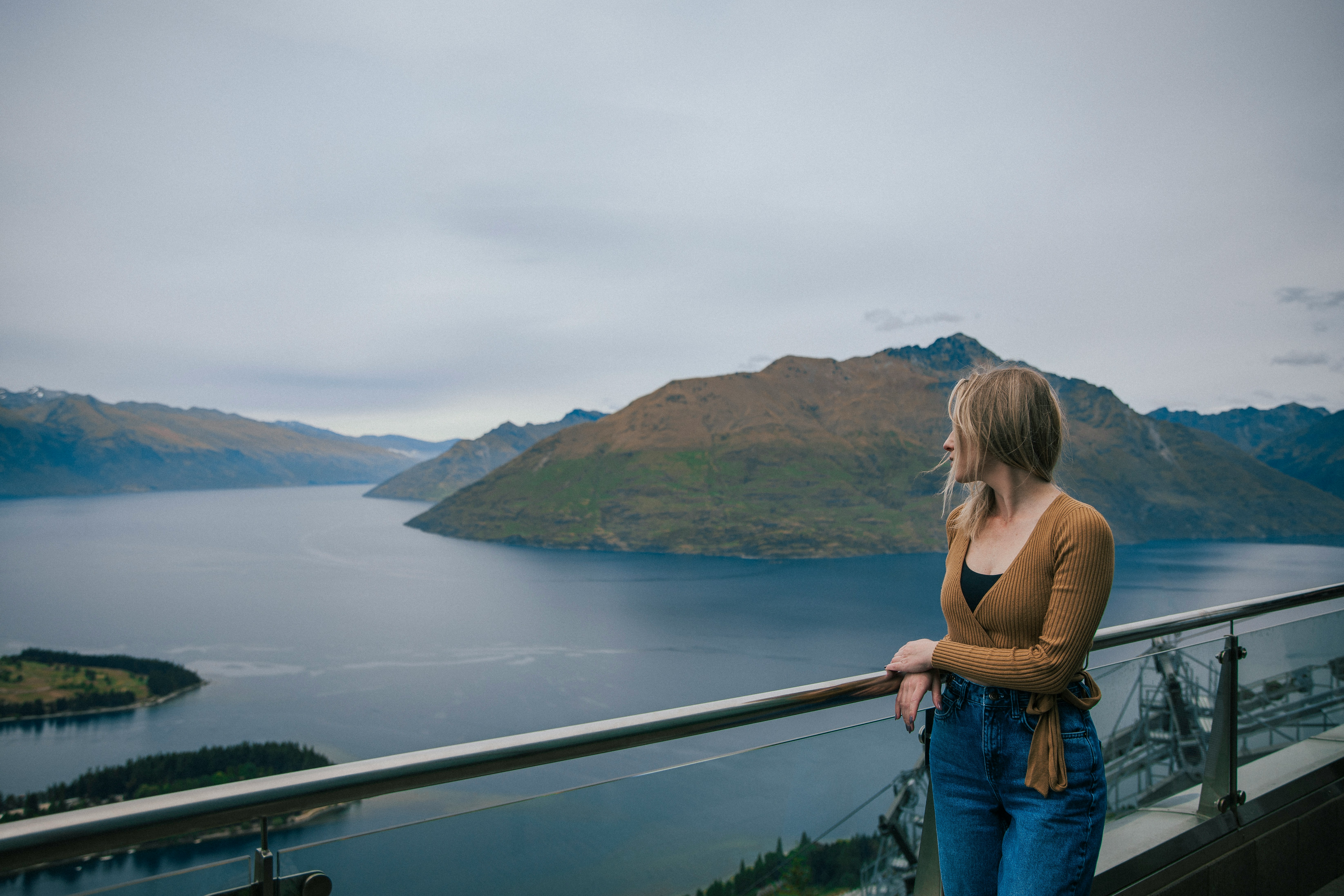 a woman standing on a balcony overlooking a body of water