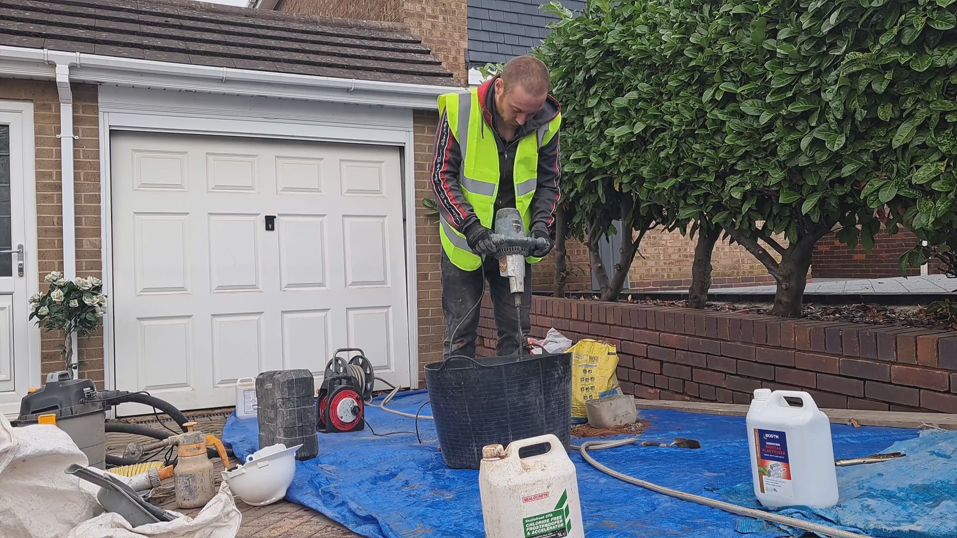 A man mixing up mortar with a paddle mixer