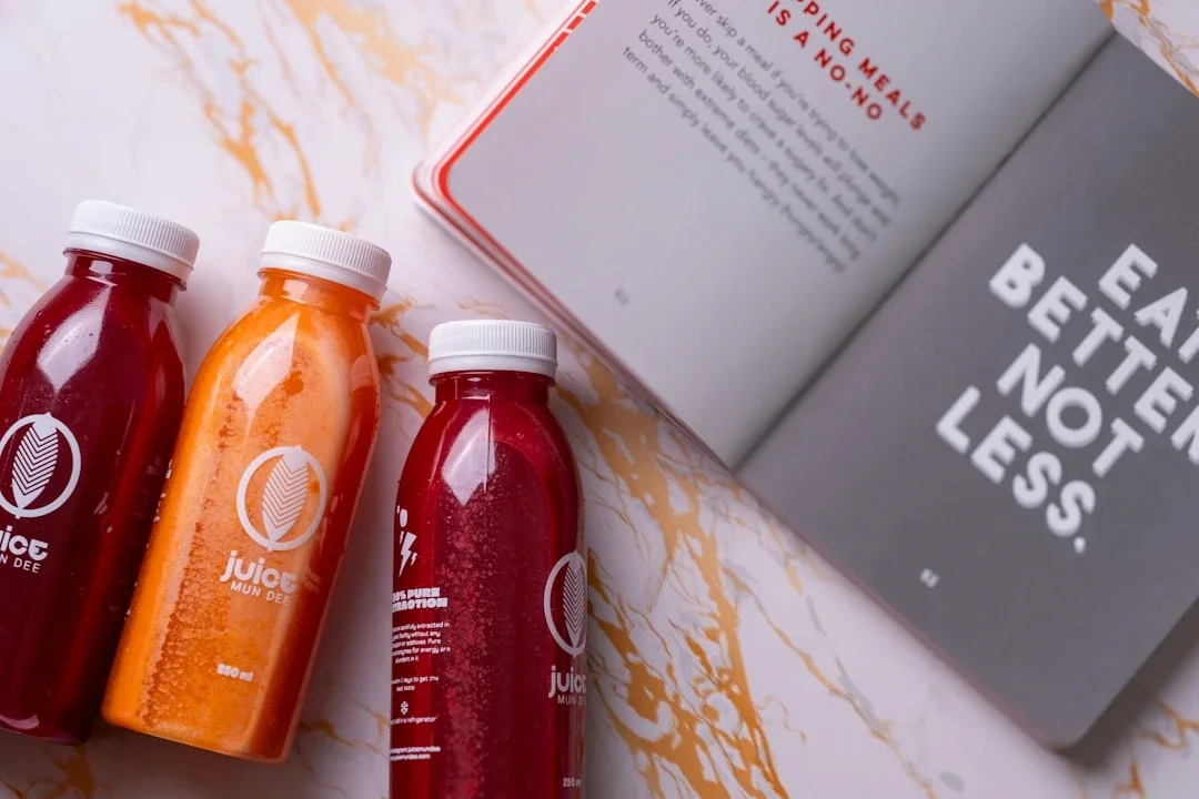 three bottles of juice next to a book