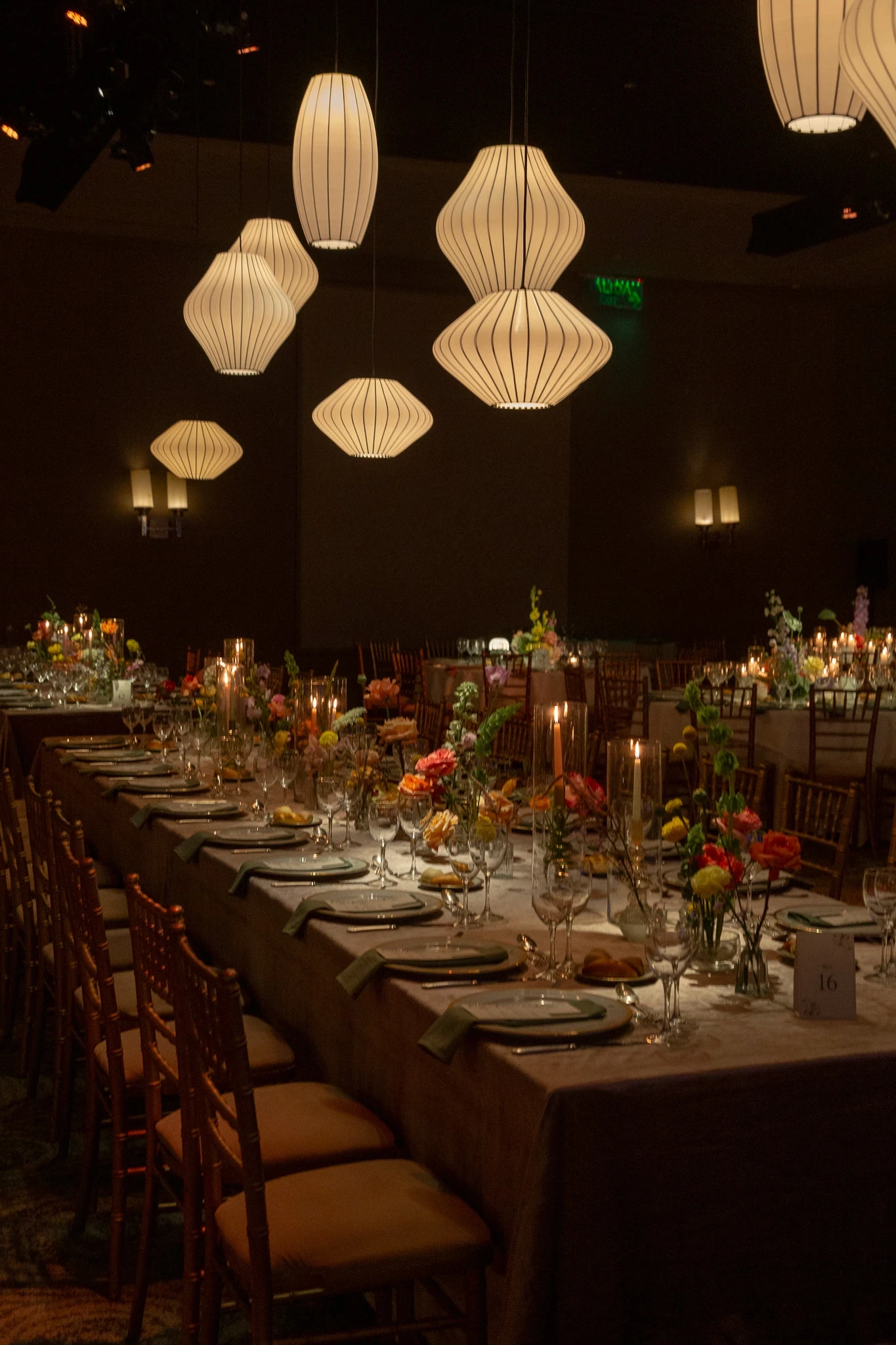 Mesa imperial de banquete con arreglos florales bajos, sillas Tiffany y lámparas de diseño en salón Alvear Icon.