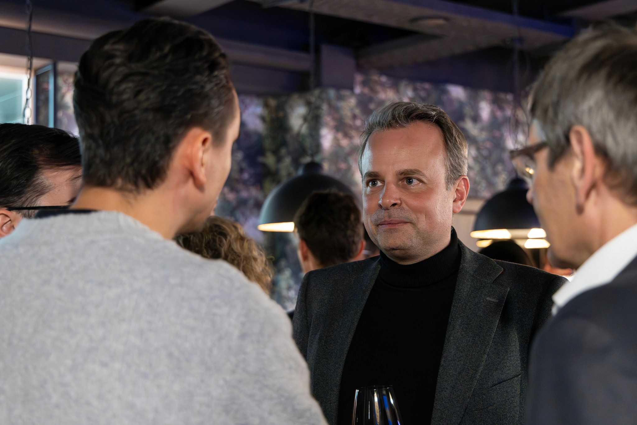 Business professionals networking at the conference reception.