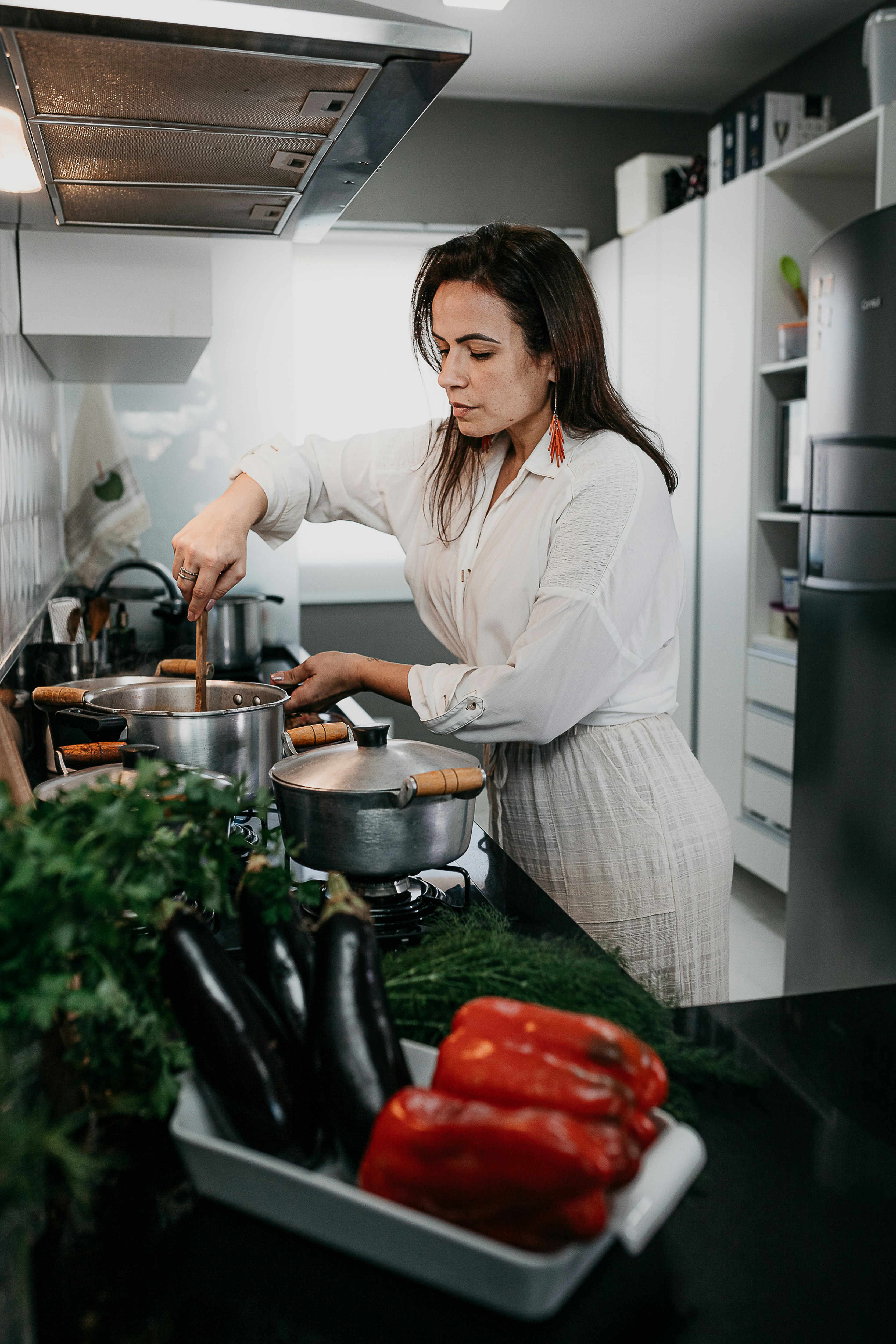 woman in white long sleeve shirt holding green vegetable