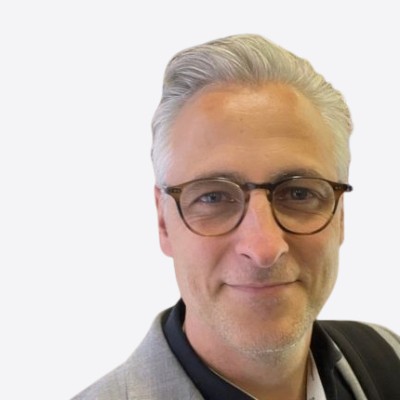 Headshot of employee, Søren Friis Alexandersen, on a blue tinted, grey background