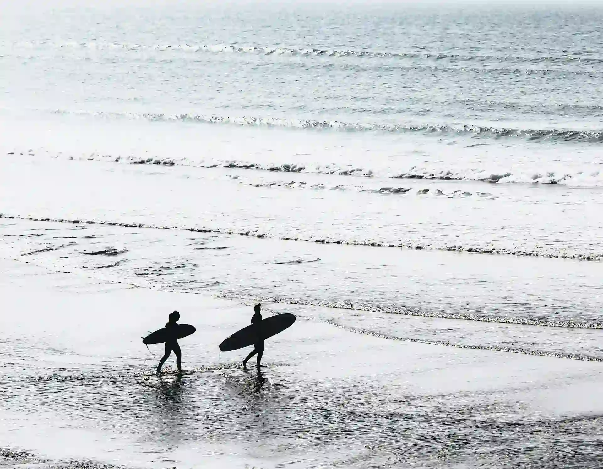 surfers walking towards the water