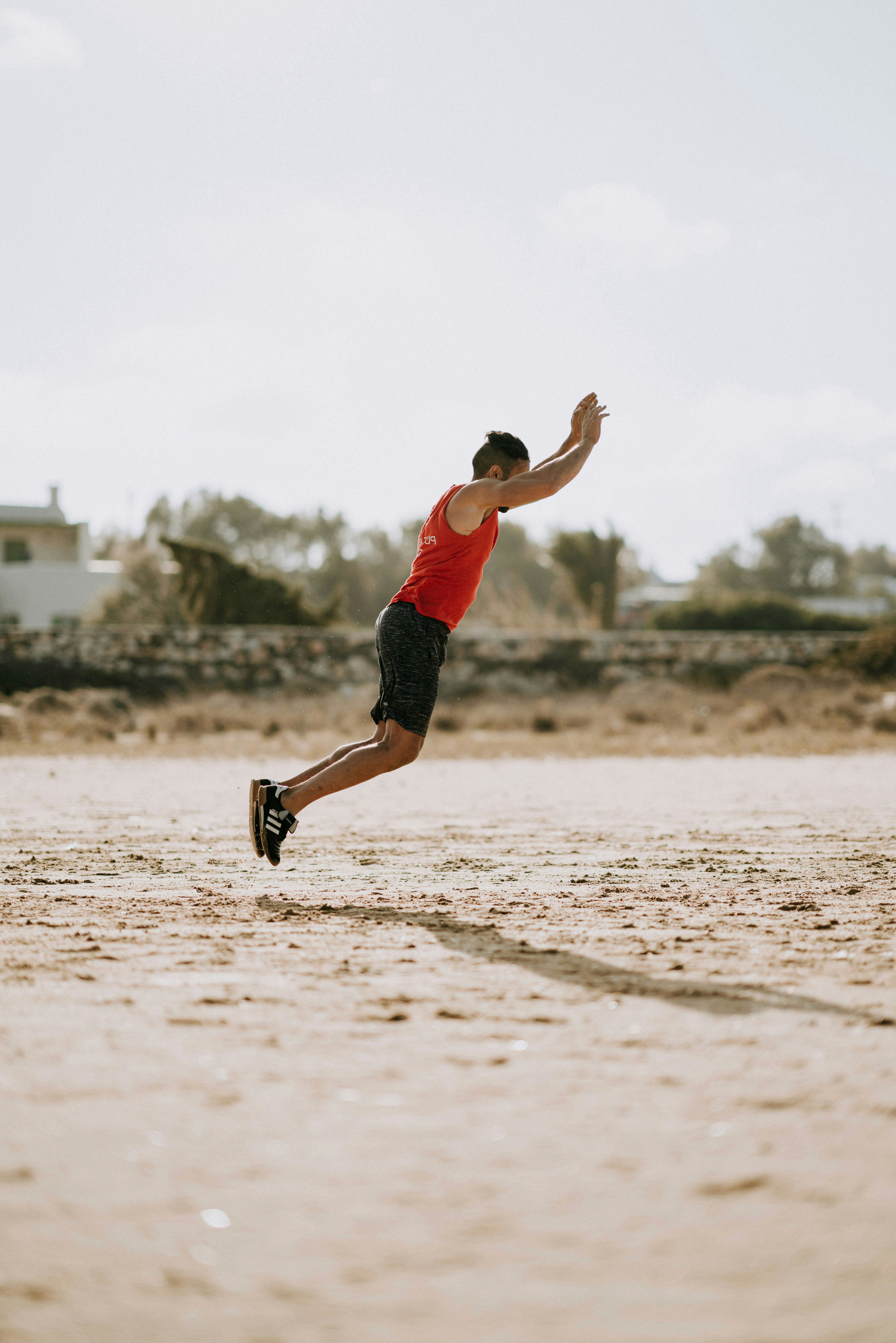 man doing broad jump on the beach