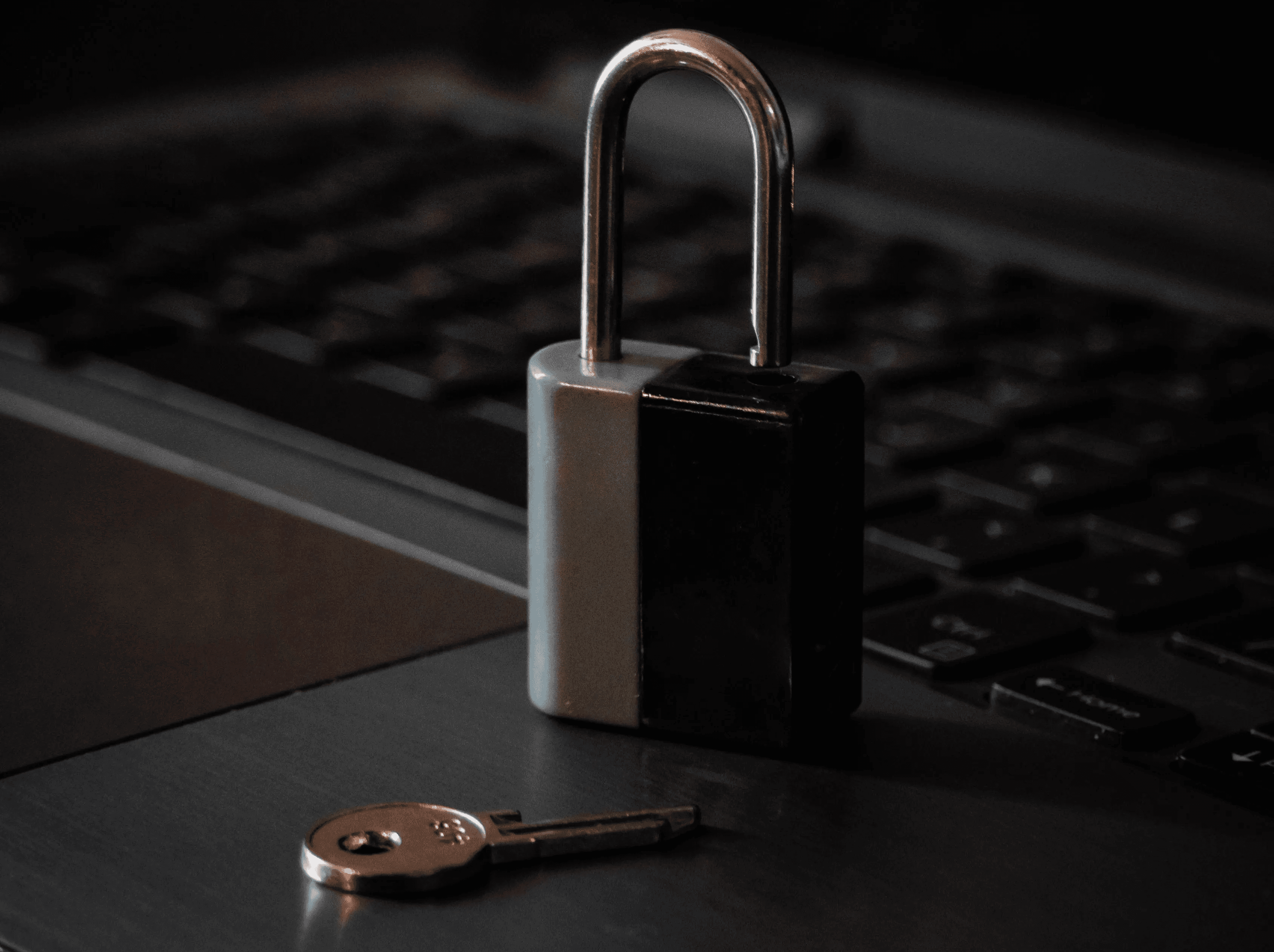 A historic village with stone buildings and a prominent bell tower, perched dramatically on a steep, eroding hilltop, accessed by a long, elevated pedestrian bridge.