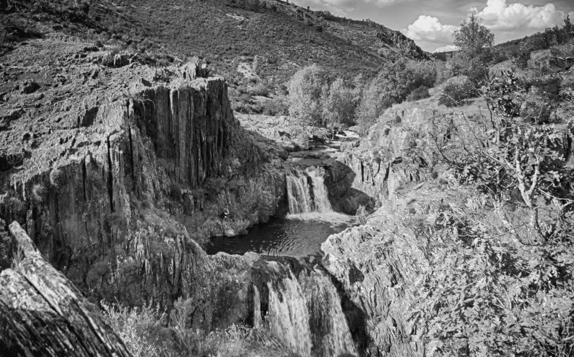 A large group photo of diverse team members gathered in an industrial-style space with arched ceiling.