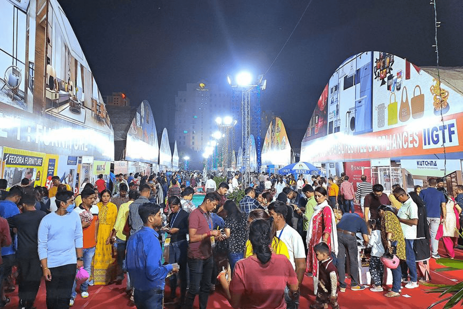 Exhibitors and visitors networking at India International Mega Trade Fair 2026 in Gyan Bhavan, Patna, surrounded by multi-category product stalls and branding.