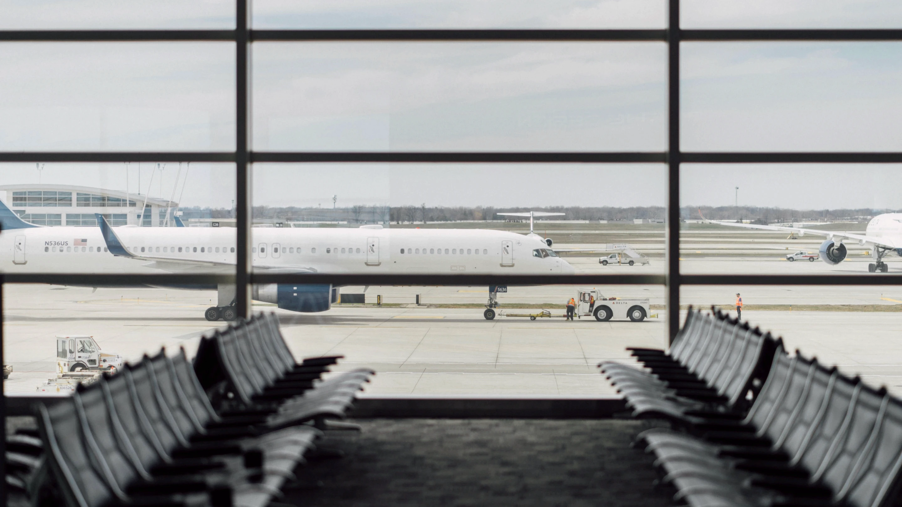 Aiport terminal seating area with a plane outside the window