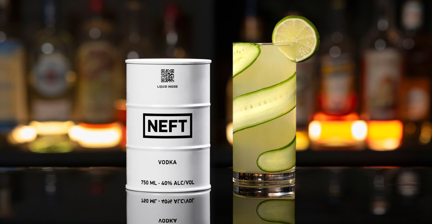 A NEFT Barrel and a glass of Cucumber Gimlet on a bar counter.