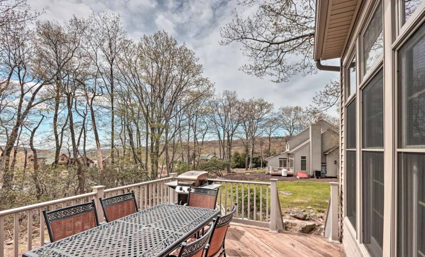 Rear deck with dining table overlooking wooded hills at SummitWind, Big Boulder, Lake Harmony, PA