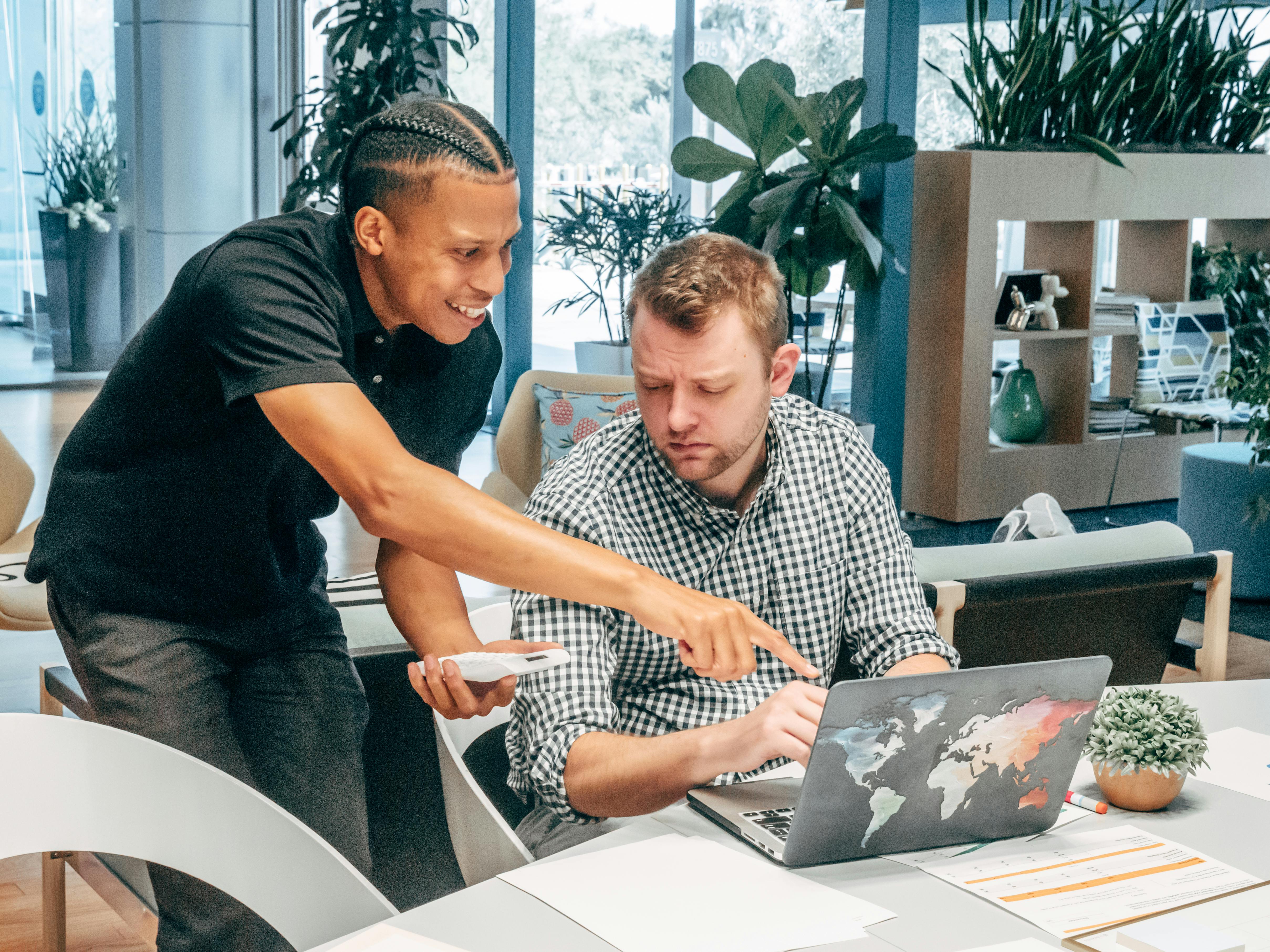 Ein B2B-Team plant an einem Whiteboard und Laptops die Implementierung von HubSpot zur Lead-Generierung und Vertriebsoptimierung.