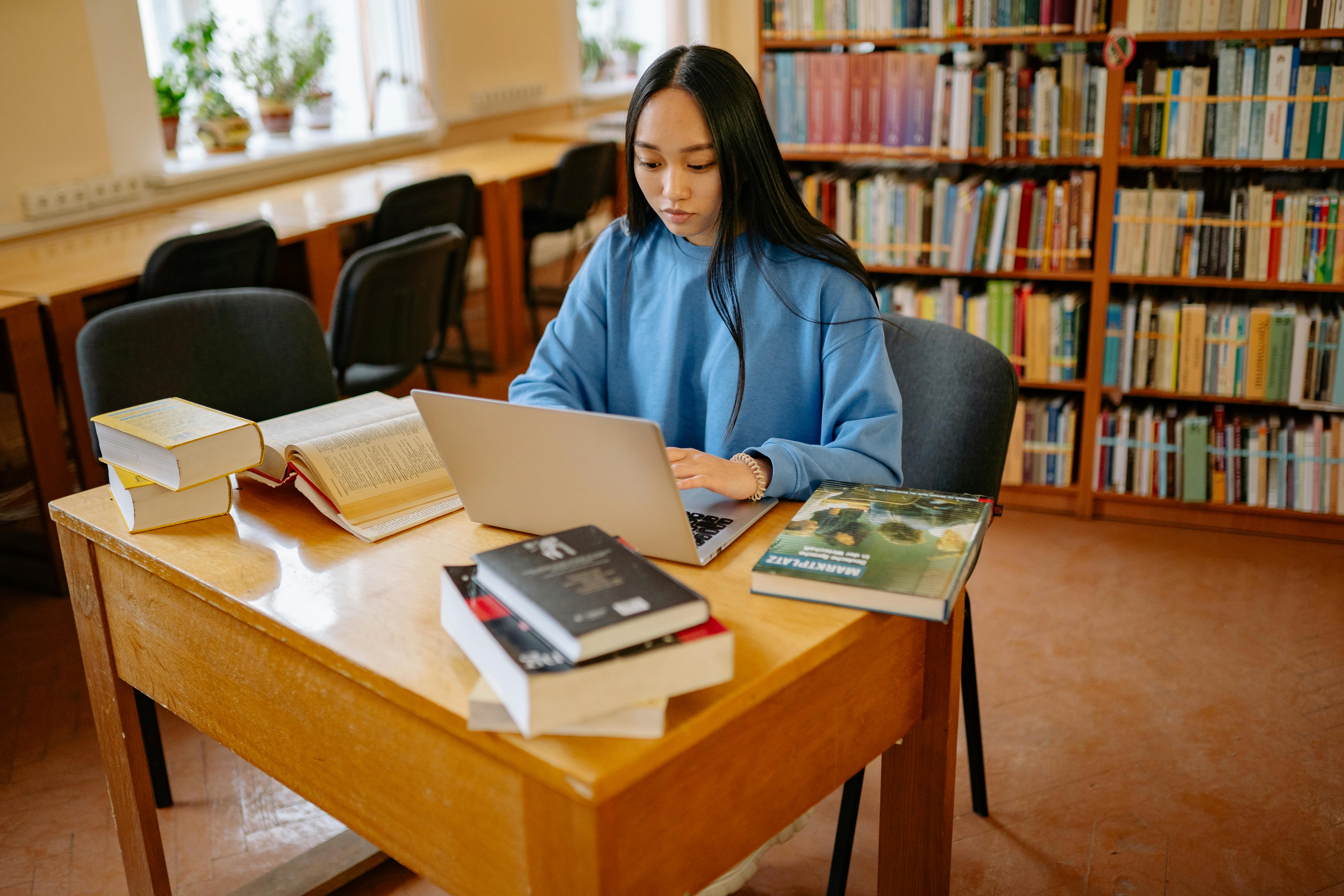 Smiling woman sitting at desk with a computer, surrounded by plants.