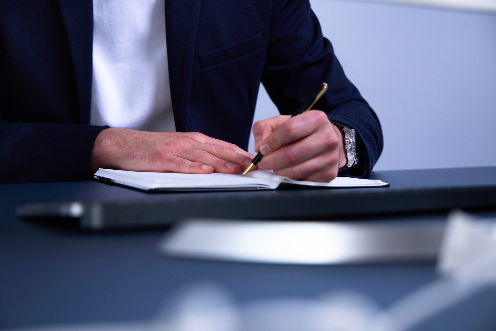 Close-up of a sleek dark green SUV with modern design elements, illuminated against a dark green background.