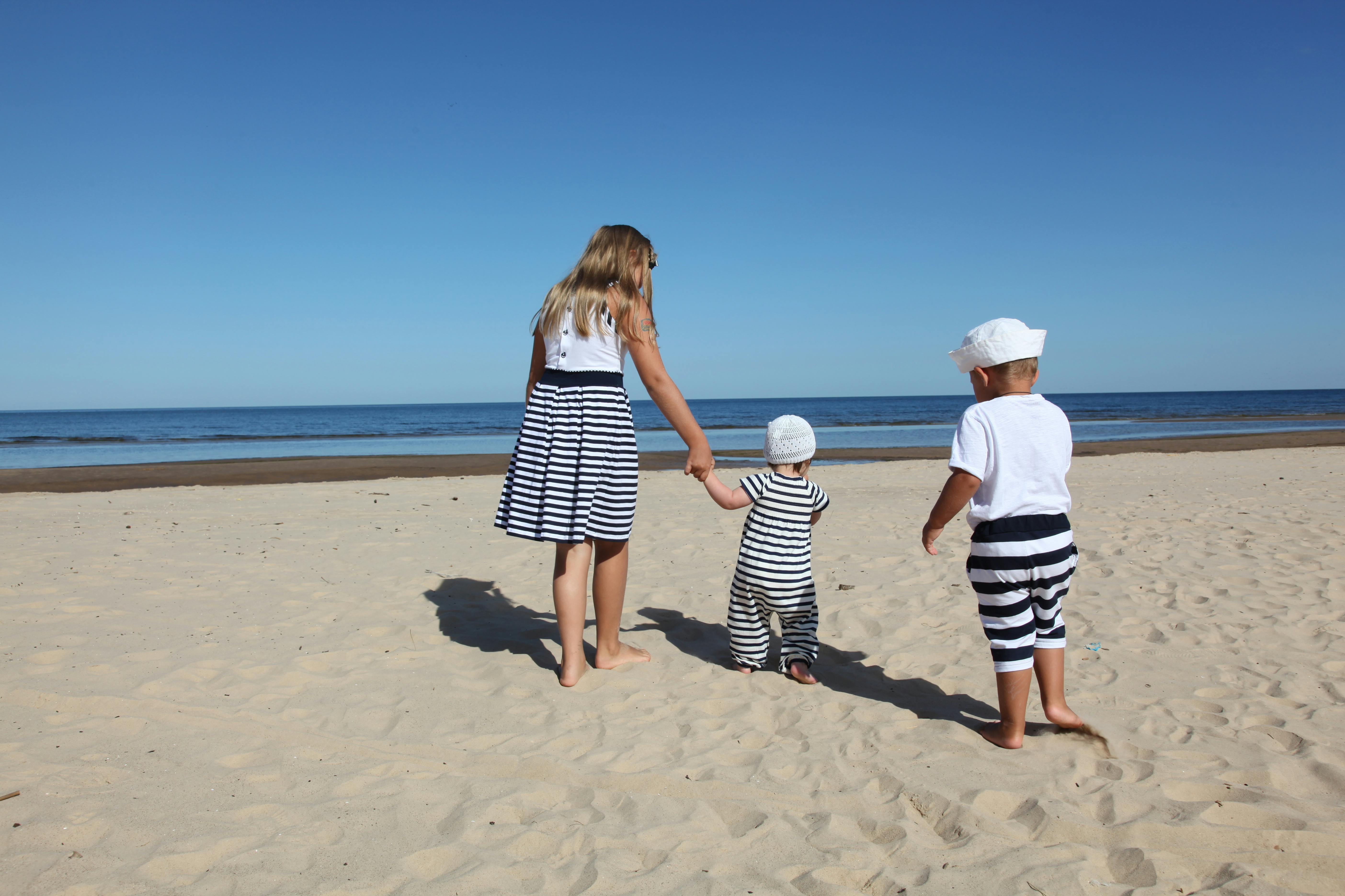 Mother and 2 children walking on a sandy beach