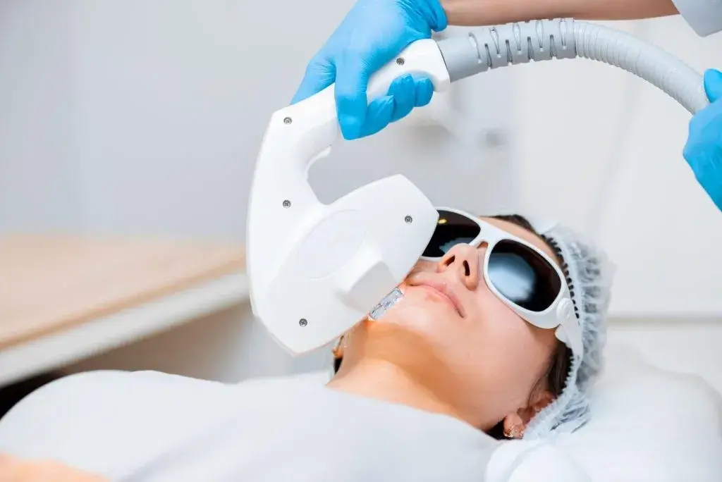 Patient receiving IPL photofacial treatment with protective eyewear, using light therapy to reduce redness, sun damage, and uneven skin tone for smoother results.