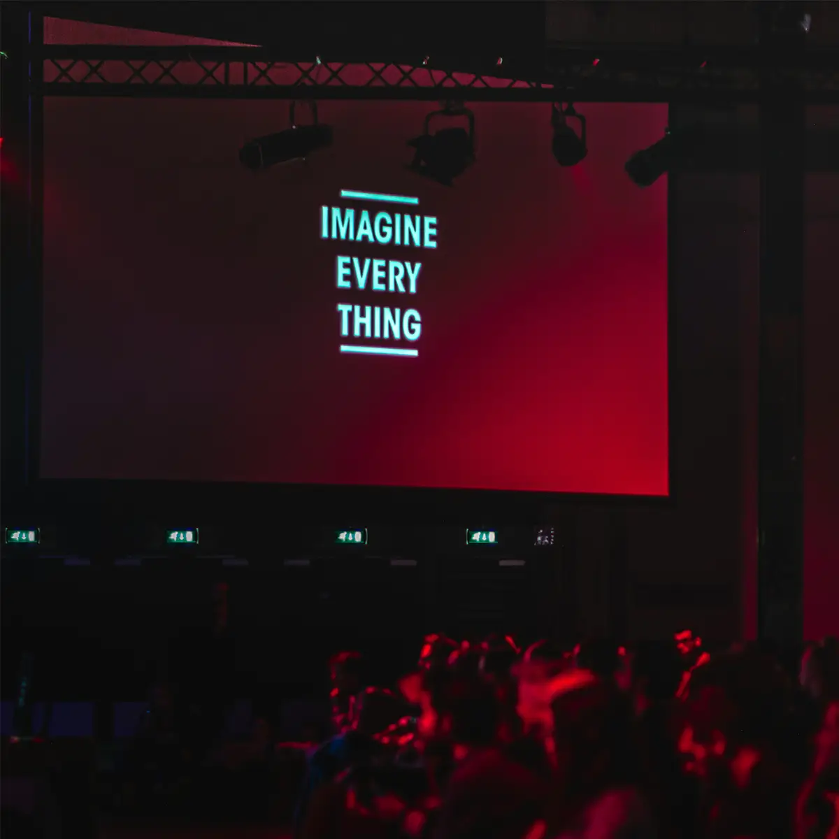 picture of someone presenting to an audience with the presentation text "imagine every thing" on a large screen