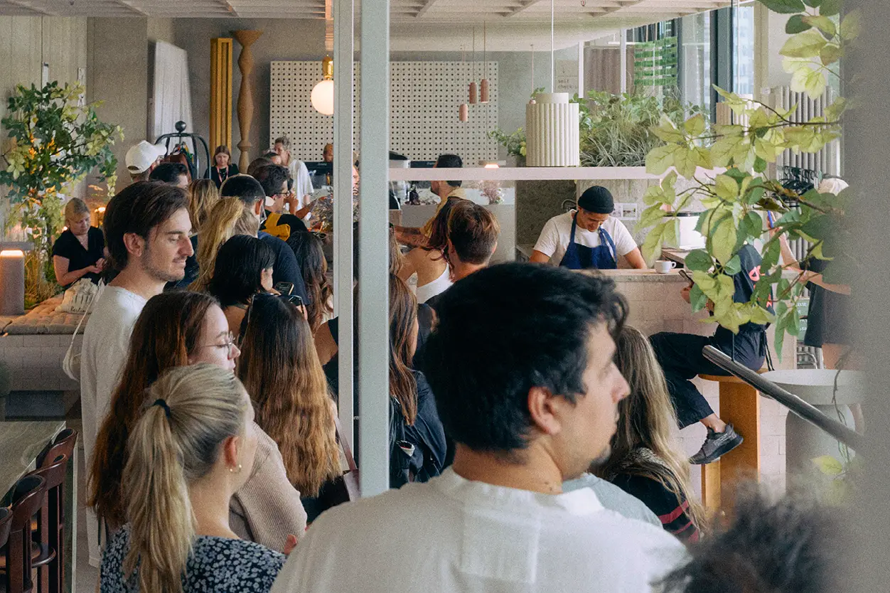 Long line of people inside restaurant waiting to order burritos.