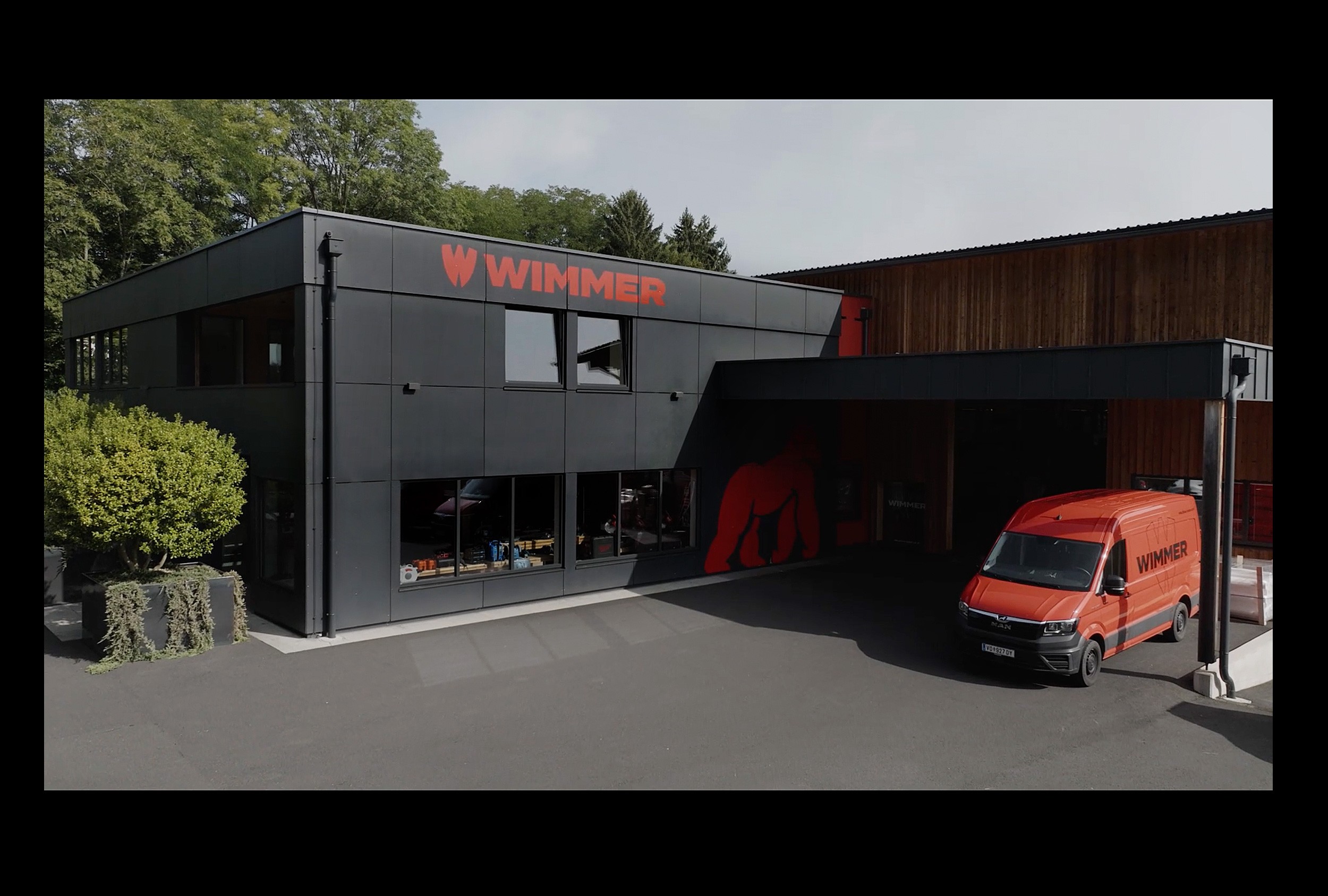 Fotografie der Laden- oder Messegestaltung mit großflächigem Branding für den Wimmer Holzbau-Shop, das die handwerkliche Kompetenz unterstreicht.