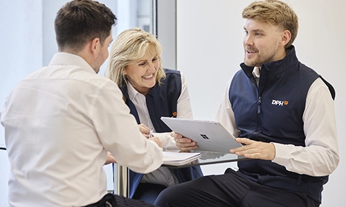 Entrance of a modern glass building with illuminated facade and reflections